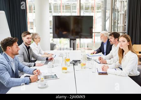 Geschäftsleute in einer Besprechung am Konferenztisch während einer Verhandlung oder Konsultation Stockfoto