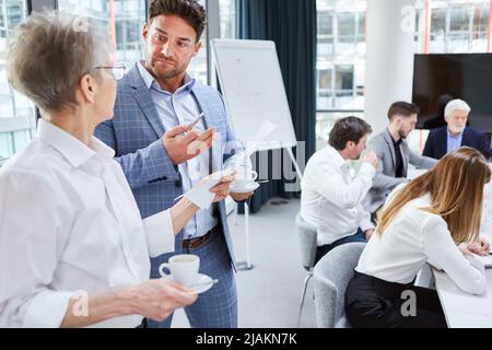 Junge Gründerin und Senior Businesswoman im Büro diskutieren über ein Business-Projekt Stockfoto