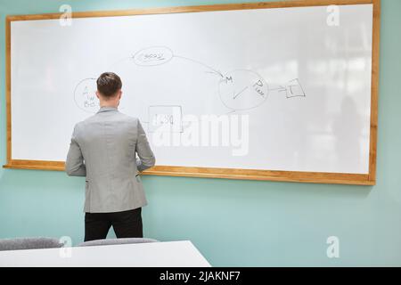 Junger Wissenschaftler als Dozent am Whiteboard, der in einem Vortrag einen Vortrag hält Stockfoto