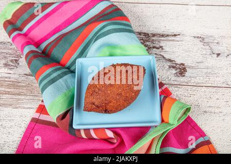 Kibbeh auf weißem Holzhintergrund. Kibbeh ist ein beliebtes Gericht in der nahöstlichen Küche. Gefüllte Fleischbällchen Essen, Falafel, icli Kofta, Quibe. Draufsicht. E Stockfoto