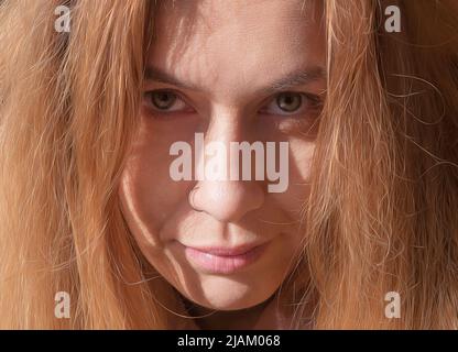 Porträt einer blonden Frau mit ernsten Gesichtsausdrücken. Nahaufnahme des Fotos im Vollbildmodus Stockfoto