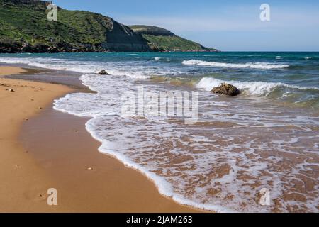 Wellen brechen am einsamen Sandstrand von Ramla Bay, Gozo, Malta Stockfoto