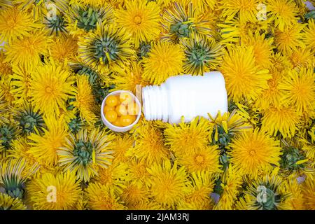 Vitamine in den Delelionen. Eine Flasche mit gelben Pillen in den Blumen des Dandelions, Nahaufnahme Stockfoto