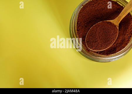 Gemahlener Kaffee in Holzlöffel auf gelbem Hintergrund Stockfoto