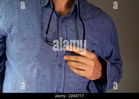 Detail eines Mannes in einem blauen Hemd Stockfoto