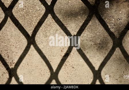 Hintergrund eines Zaunschattens auf der Steinmauer Stockfoto