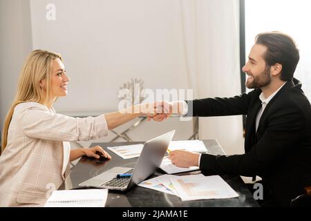 Starke Zustimmung. Seitenansicht des Handshake mit Dankbarkeit. Mann und Frau schütteln sich die Hände, um die Partnerschaft anzuerkennen. Stock Foto Stockfoto