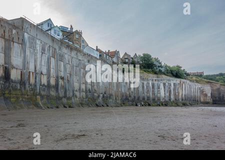 Die massive Meeresmauer in Robin Hood's Bay, North Yorkshire, Großbritannien. Die Betonmauer wurde in den 1970er Jahren gebaut, um das kleine Dorf vor dem Meer zu schützen. Stockfoto