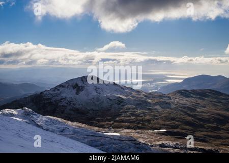 Blick auf Yr Aran und die Küste vom Rhyd DDU-Pfad auf den Pisten von Snowdon im Winter im Snowdonia National Park. Rhyd DDU, Gwynedd, North Wales, Großbritannien Stockfoto