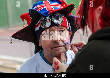 The Mall, London, Großbritannien. 31.. Mai 2022. Amy Thompson, die aus Newcastle angereist ist, malt die Unionsflagge auf John Loughreys Wange. Die Royal Supermans haben im Vorfeld des Queens Platinum Jubilee-Jubiläums begonnen, sich auf der Mall zu kampieren. Kredit: amanda Rose/Alamy Live Nachrichten Stockfoto