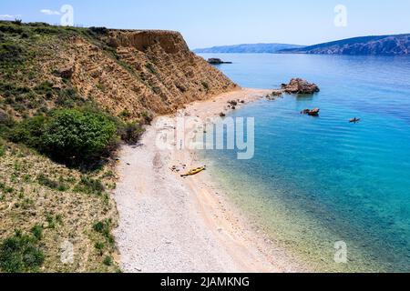 Touristen mit Kajaks genießen einen wunderschönen Strand auf Prvic Island, Kroatien, Stockfoto