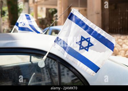 Sie winkten mit den israelischen Flaggen, die am Autofenster befestigt sind. Stockfoto