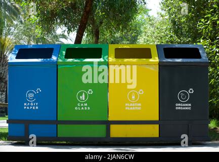 Verschiedenfarbige Abfallbehälter mit Aufschriften aus Papier, Kunststoff, Glas und organischen Abfällen, die recyclinggeeignet sind. Abfall trennen, Müll sortieren Stockfoto