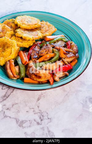 Gehacktes Steak oder Bistec Picao und Patacone oder Tostones sind frittierte grüne Kochbananen, die mit grünen Kochbananen, typisch lateinisches Essen, Panamá, zubereitet werden Stockfoto