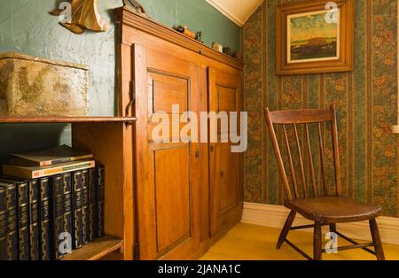 Antiker Stuhl und Möbel im Hauptschlafzimmer im Obergeschoss im alten, ca. 1810 Jahre alten Haus im kanadischen Cottage-Stil. Stockfoto