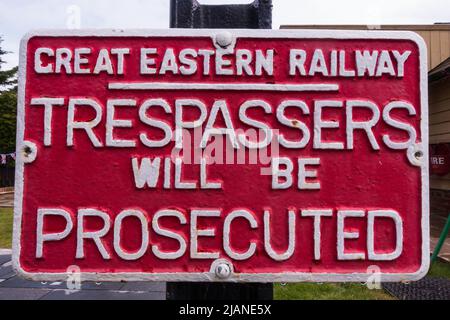 Great Eastern Railway, Hausfriedensbruch wird verfolgt werden Gusseisen Zeichen in rot mit weißen Schriftzügen. Bannold Station, Fen Drayton, Cambridgeshire. Stockfoto