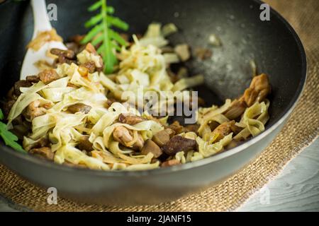 Hausgemachte gekochte Nudeln mit Fleisch und Auberginen in einer Pfanne Stockfoto