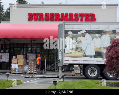 Mill Creek, WA USA - ca. Mai 2022: Straßenansicht der Vorderseite eines Burgermaster Fast-Food-Restaurants, als sie eine Lebensmittelzustellung erhalten Stockfoto