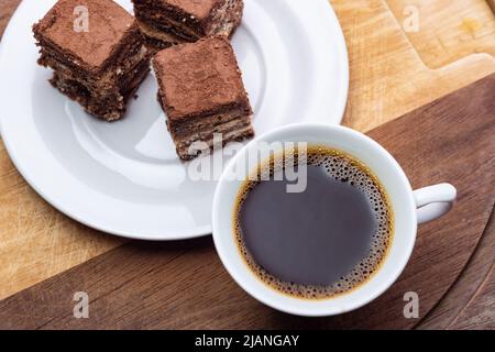 Goiânia, Goias, Brasilien – 31. Mai 2022: Eine Tasse Kaffee mit italienischen Strohstückchen auf Holzoberfläche. Stockfoto