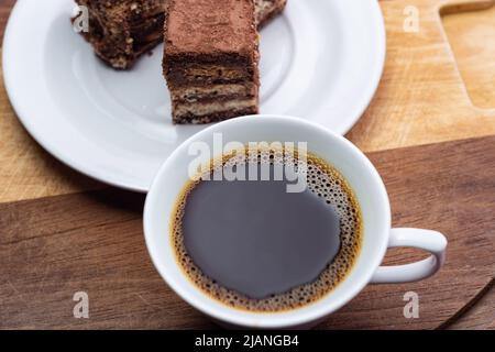 Goiânia, Goias, Brasilien – 31. Mai 2022: Eine Tasse Kaffee mit italienischen Strohstückchen auf Holzoberfläche. Stockfoto