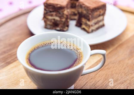 Goiânia, Goias, Brasilien – 31. Mai 2022: Eine Tasse Kaffee mit Stücken italienischen Strohhalms auf Holz auf einer rosa Oberfläche. Stockfoto