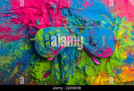 Holi Farbpulver auf Sonnenbrille. Organische Gulal Farben auf Brillen für Holi Festival, Hindu Tradition festlich Stockfoto