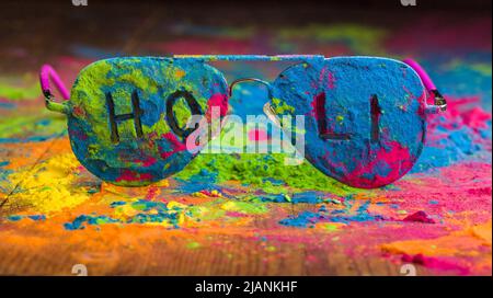 Holi Farbpulver auf Sonnenbrille. Organische Gulal Farben auf Brillen für Holi Festival, Hindu Tradition festlich Stockfoto
