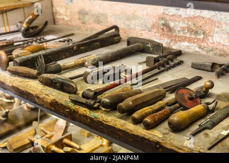 Sammlung von Vintage-Holzbearbeitungswerkzeuge auf einer rauen Werkbank und leeren Kopieraum: Zimmerei Stockfoto
