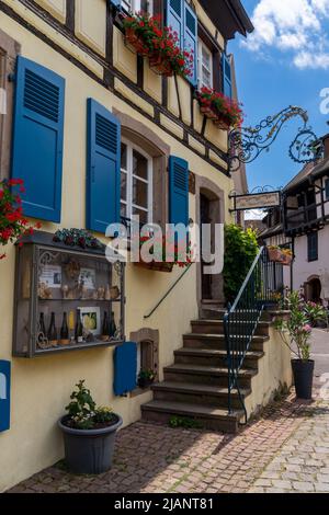 Eguisheim, Frankreich - 29. Mai 2022: Historischer, farbenfroher Weinkeller im Dorfzentrum von Eguisheim Stockfoto