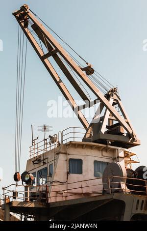 Schiffskran ist unter blauem Himmel, vertikales Foto Stockfoto