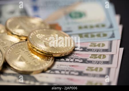 Bitcoins stapelten sich auf hundert Dollarscheinen. Tausch digitale Währung mit Dollar-Konzept Stockfoto