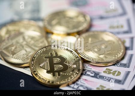 Bitcoin auf 50-Dollar-Banknoten, Nahaufnahme von Bitcoin-Goldmünzen auf 50-Dollar-Papierscheinen. Stockfoto