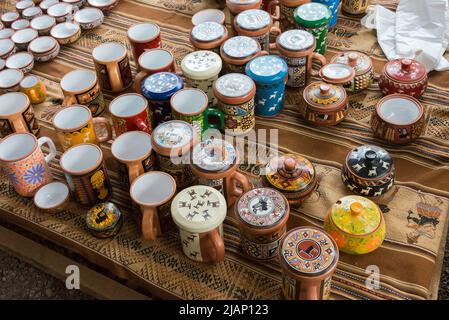 Bunte handgemachte Töpfe an einem Stand, der Kunsthandwerk in Chinchero, im Heiligen Tal, Peru verkauft Stockfoto