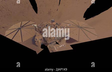 Marsoberfläche. 24. April 2022. NASA Insight Mars Lander nahm dieses letzte Selfie am 24. April 2022, dem 11. Mars-Tag, oder sol, der Mission, auf. Der Lander ist mit viel mehr Staub bedeckt als in seinem ersten Selfie, das im Dezember 2018 aufgenommen wurde, nicht lange nach der Landung. Oder in seinem zweiten Selfie, das aus Bildern von März und April 2019 besteht. Der Arm muss sich jetzt mehrmals bewegen, um ein komplettes Selfie aufzunehmen. Da die staubigen Sonnenkollektoren von Insight weniger Strom produzieren, wird das Team bald den Roboterarm des Landers für die letzte Zeit in seine Ruheposition bringen (die sogenannte „Ruhestätte“) Stockfoto