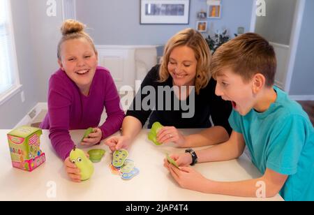 Familienspiel-Nacht mit Mutter, Tochter und Sohn an der Küchentheke Stockfoto