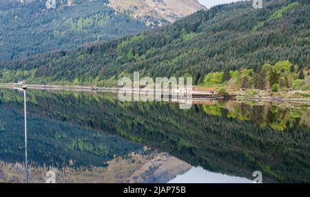 Eine malerische Aussicht auf Loch Long bei Arrochar, Schottland, UK mit Spiegel wie Reflexionen von den Bergen in das Loch. Stockfoto