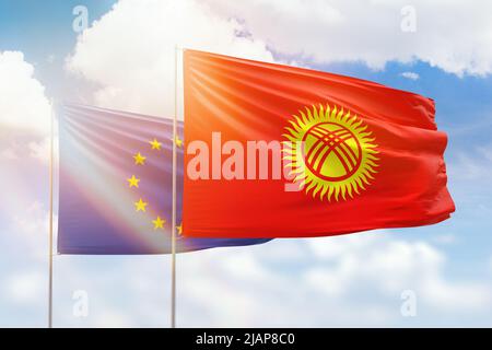 Sonniger blauer Himmel und Flaggen kirgisistans und der europäischen Union Stockfoto