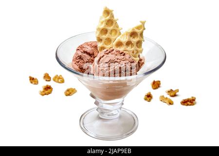 Hausgemachtes Schokoladeneis in einer Glasschüssel mit zerdrückter weißer Schokolade und Walnüssen auf weißem Hintergrund Stockfoto