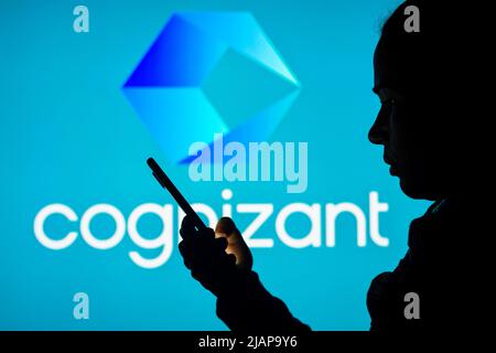 Brasilien. 31.. Mai 2022. In dieser Abbildung ist das Logo der Cognizant Technology Solutions Corporation im Hintergrund einer Frau mit Silhouetten zu sehen, die ein Mobiltelefon in der Hand hält. (Bild: © Rafael Henrique/SOPA Images via ZUMA Press Wire) Stockfoto