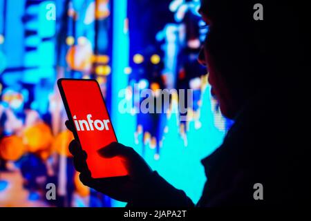 Brasilien. 31.. Mai 2022. In dieser Abbildung hält eine Frau mit Silhouetten ein Smartphone mit dem Infor-Logo auf dem Bildschirm. (Foto von Rafael Henrique/SOPA Images/Sipa USA) Quelle: SIPA USA/Alamy Live News Stockfoto