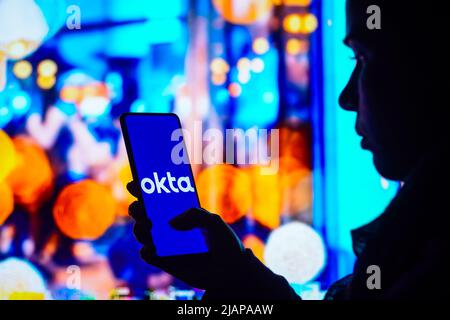 Brasilien. 31.. Mai 2022. In dieser Abbildung hält eine Frau mit Silhouetten ein Smartphone mit dem Okta-Logo auf dem Bildschirm. (Foto von Rafael Henrique/SOPA Images/Sipa USA) Quelle: SIPA USA/Alamy Live News Stockfoto