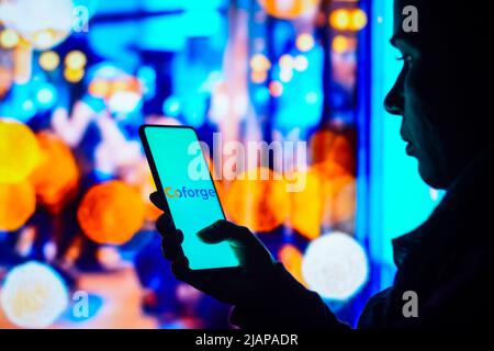 Brasilien. 31.. Mai 2022. In dieser Abbildung hält eine Frau mit Silhouetten ein Smartphone mit dem Coforge-Logo auf dem Bildschirm. (Foto von Rafael Henrique/SOPA Images/Sipa USA) Quelle: SIPA USA/Alamy Live News Stockfoto