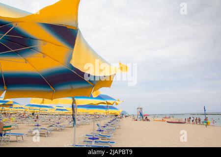 Sonnenschirme und Sofas am blauen Himmel und Meeresgrund am Strand von Italien. Beliebte Tourist Resort an der Adria am Strand von , Rimini Adriatic Stockfoto