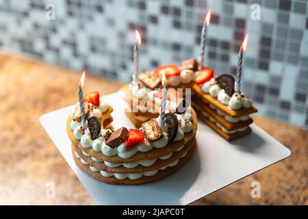 Kuchen in Form von Nummer fünf, mit Kekskuchen und Käsecreme und mit Keksen und Beeren verziert. Anzahl der Jahre. Dessert mit Cremekäsen Stockfoto