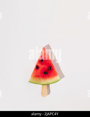 Eis aus Wassermelonenscheibe auf grauem Hintergrund mit Kopierraum. Modernes Sommerkonzept. Flach liegend. Stockfoto