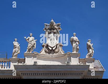 Architektonisches Detail neoklassischer Skulpturen und Wappen auf dem Dach des Petersdoms, des Petersplatzes, der Vatikanstadt, Rom, Italien. Die päpstliche Basilika St. Peter im Vatikan (italienisch: Basilica Papale di San Pietro in Vaticano) oder einfach der Petersdom (lateinisch: Basilica Sancti Petri) ist eine Kirche im Renaissancestil im Vatikanstadt, der päpstlichen Enklave, die sich innerhalb der Stadt Rom, Italien, befindet Stockfoto