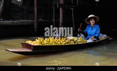 Eine Thailänderin, die Obst von einem Boot auf dem schwimmenden Markt von Damnoen Saduak in Thailand verkauft. Damnoen Saduak ist ein Distrikt in der Provinz Ratchaburi im Westen Thailands. Stockfoto