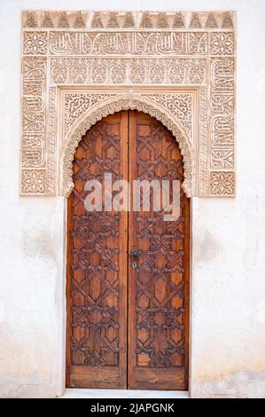 Beispiel mittelalterlicher geometrischer Ornamente an alten Holztüren in Granada, Andalusien, Spanien Stockfoto