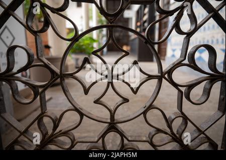 Beispiel für mittelalterliche maurische symmetrische und geometrische Ornamente an Eisentüren in Granada, Andalusien, Spanien Stockfoto