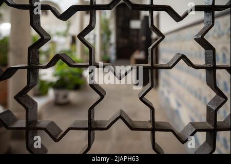 Beispiel für mittelalterliche maurische symmetrische und geometrische Ornamente an Eisentüren in Granada, Andalusien, Spanien Stockfoto